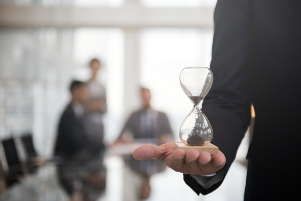 Businessman Holding An Hour Glass, Signifies The Importance Of Being On Time - OFFICE CONT - Contabilidade Digital para você e sua empresa